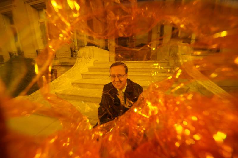 Frédéric Rouzaud - Roederer. Frédéric sits on the steps of his family home in Reims. The lens has been rapped in the famous cellophane of Cristal.